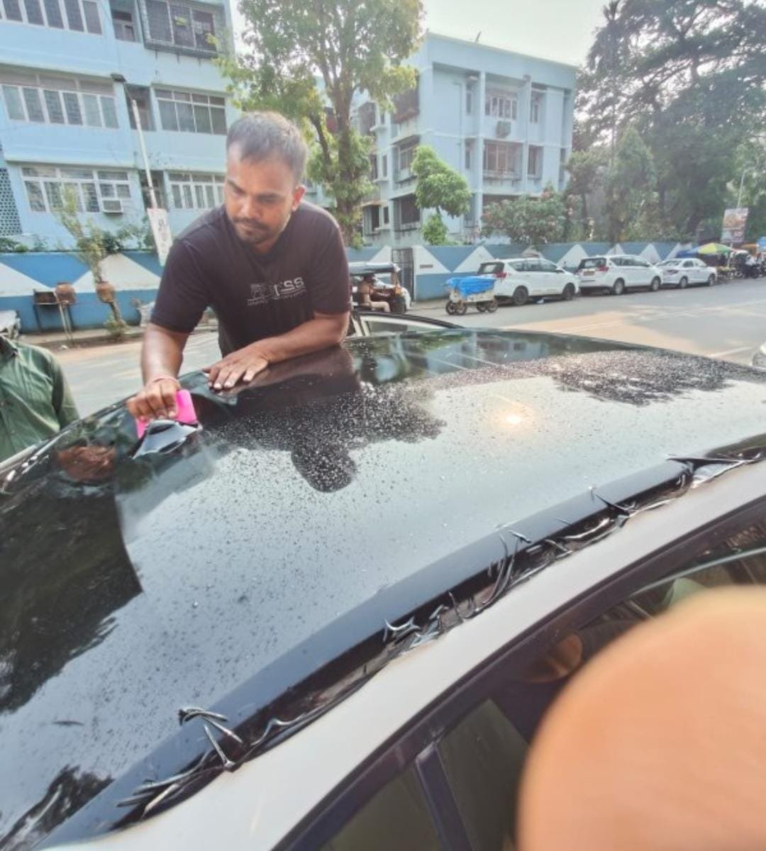 M7WRAP technician squeegeeing black roof film onto a car roof